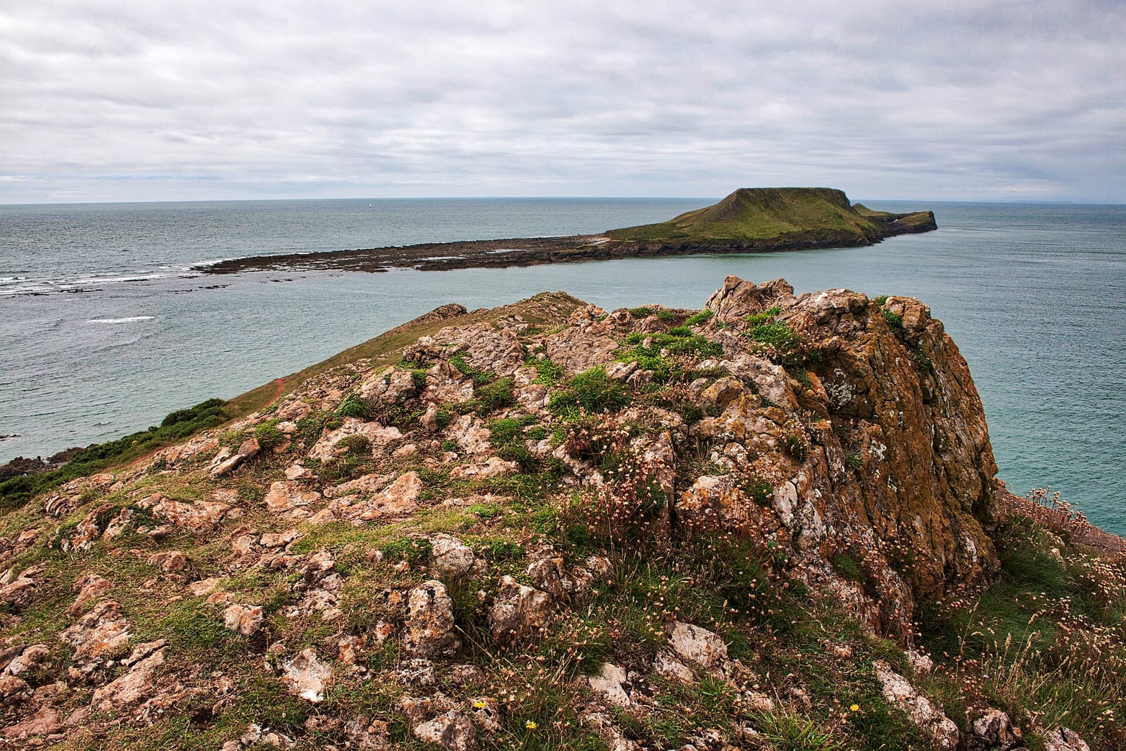 The tidal causeway of Worm's Head reaching out from Rhossili on Gower